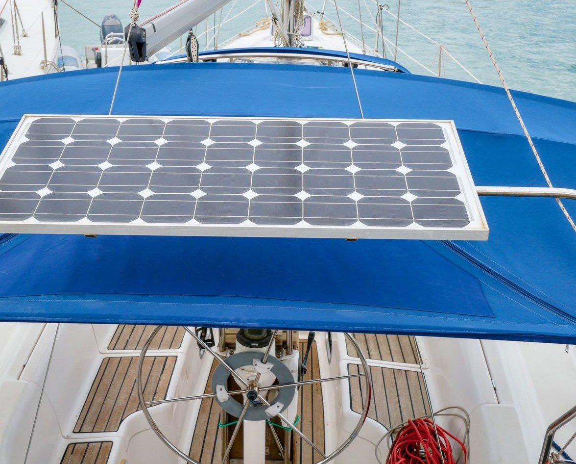 Solar panel mounted over the cockpit of a sailing yacht, charging the vessel's 24V house battery bank