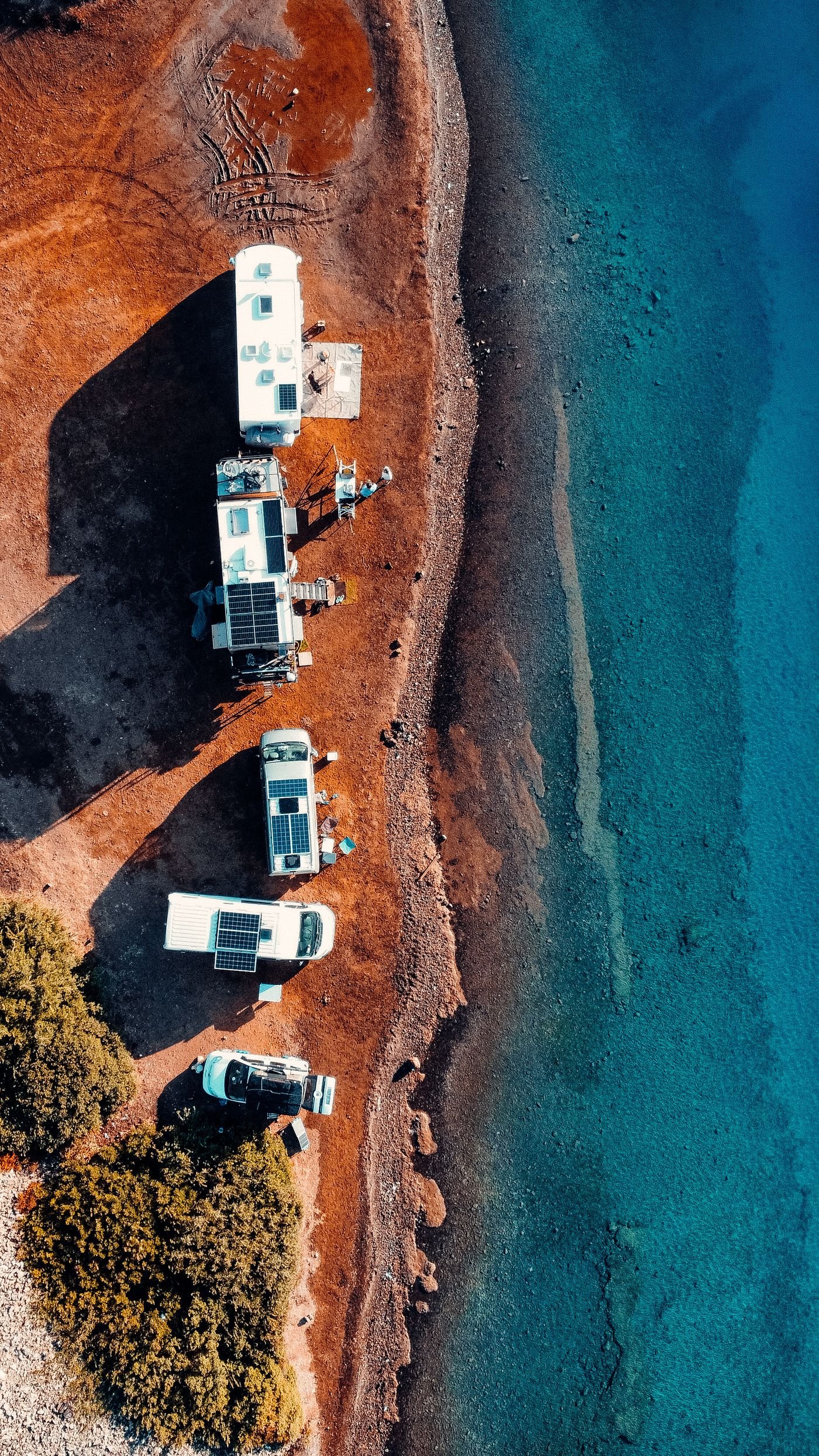Aerial view of camper vans and motorhomes with rooftop solar panels parked by the sea, typical 12V 200Ah LiFePO4 battery applications